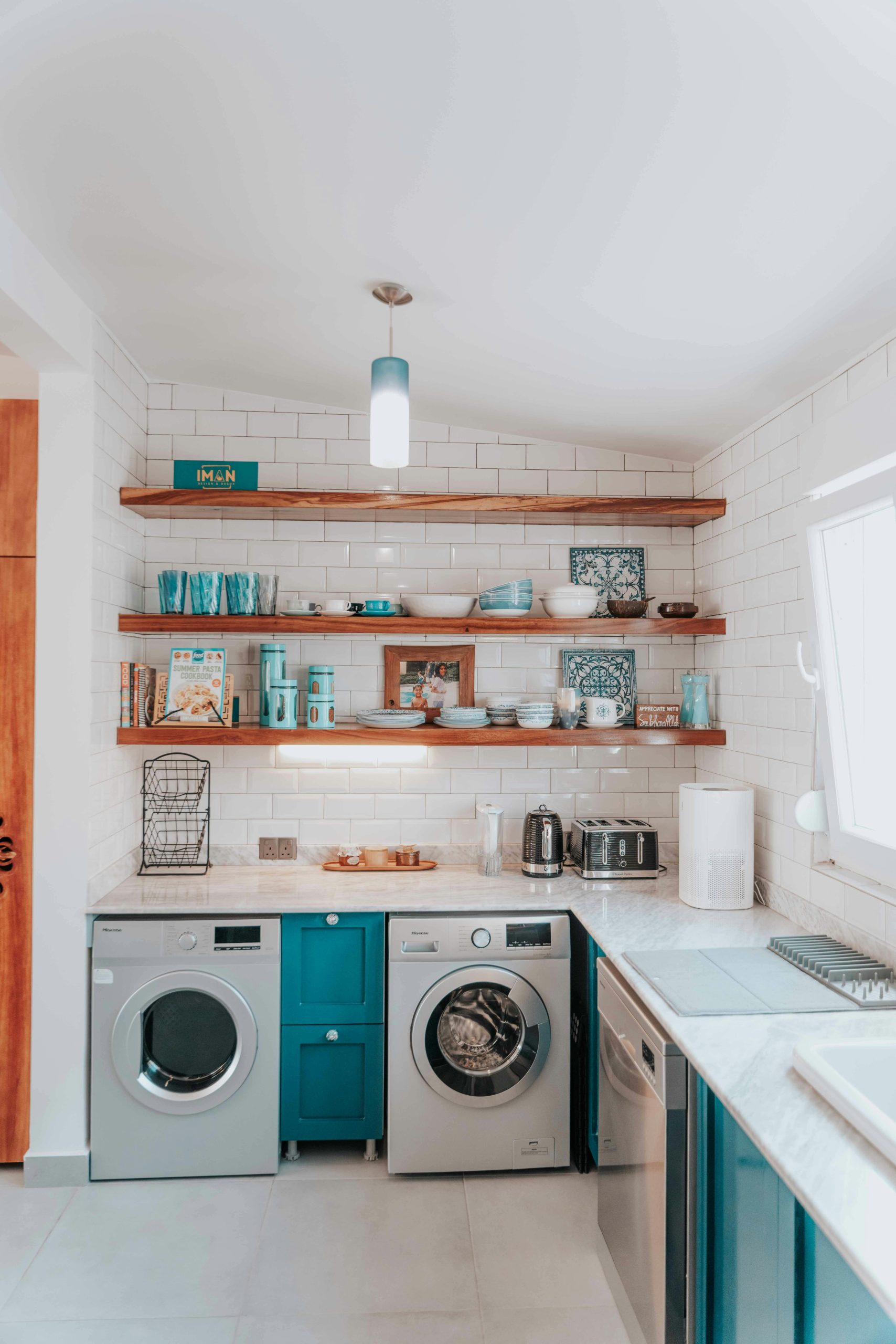 A bright modern kitchen featuring open shelving and integrated washing appliances.